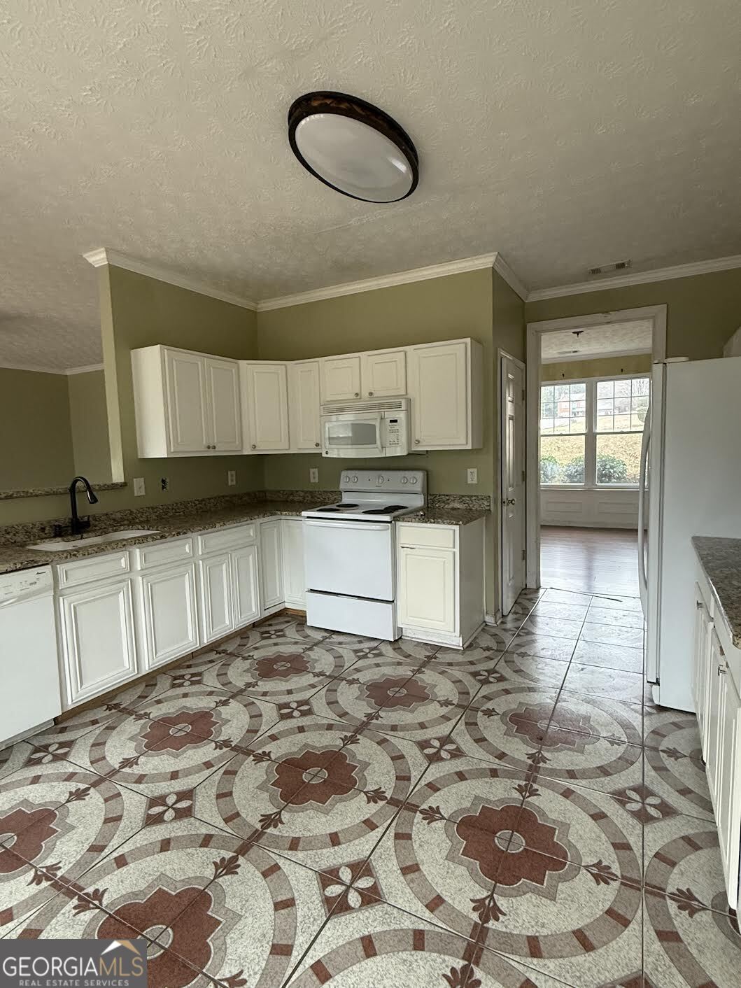 965 Trotters Farm Road Fairburn, GA 30213 - Photo 2 of 6 a kitchen with granite countertop a sink a stove cabinets and counter space