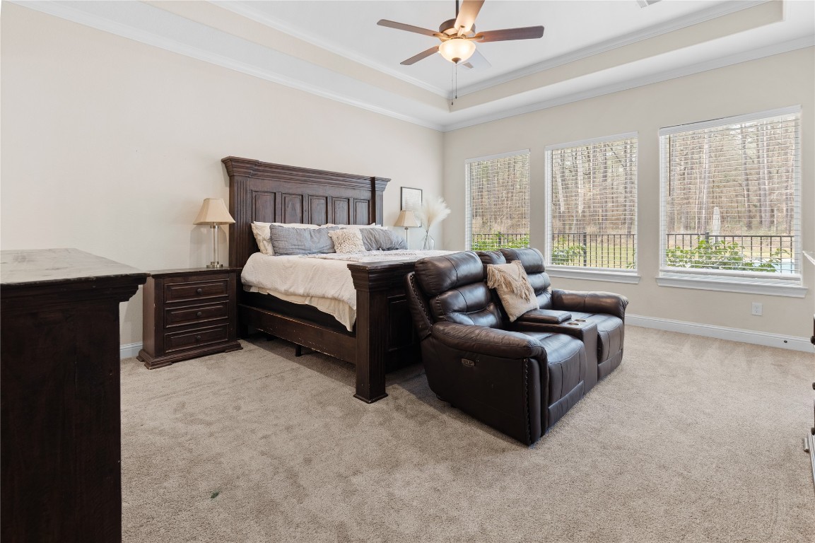 141 Sundog Road Huntsville, TX 77340 - Photo 16 of 49 a spacious bedroom with a bed and a chandelier