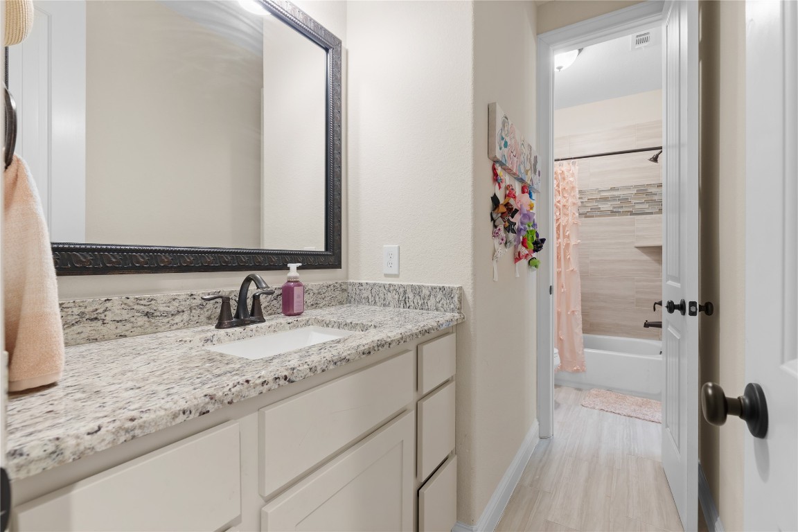141 Sundog Road Huntsville, TX 77340 - Photo 29 of 49 a bathroom with a granite countertop sink a mirror and a shower