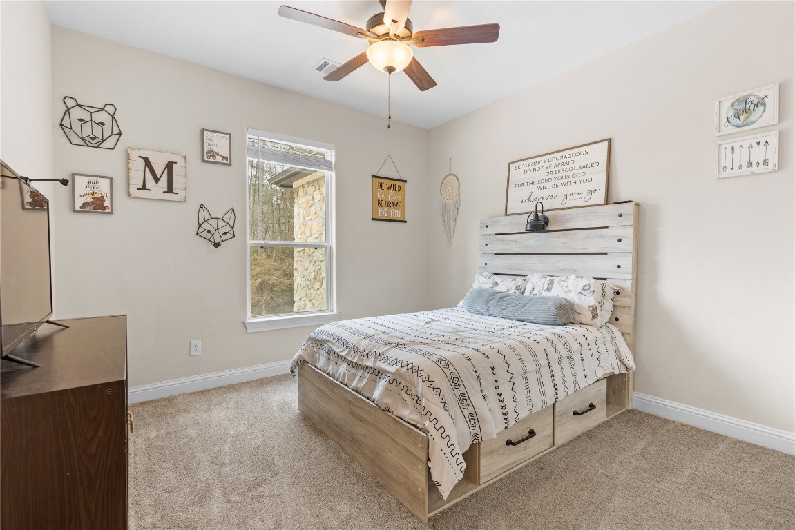 141 Sundog Road Huntsville, TX 77340 - Photo 34 of 49 a bedroom with a bed and a chandelier