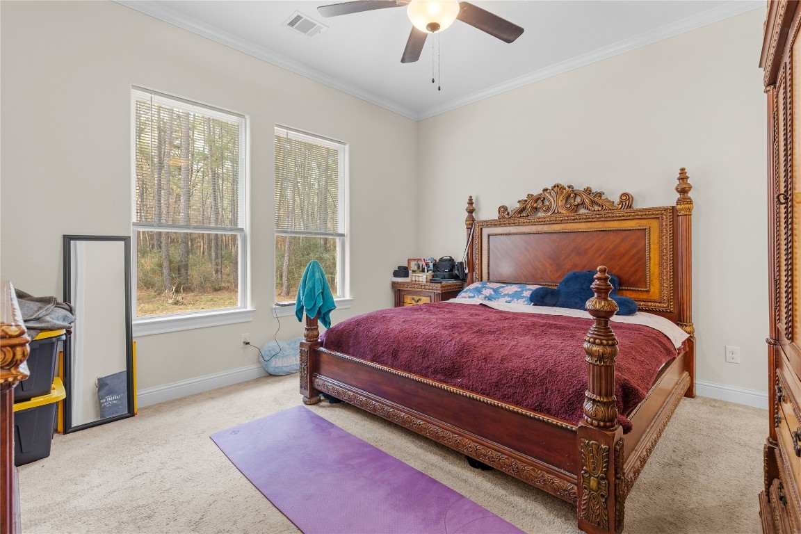 141 Sundog Road Huntsville, TX 77340 - Photo 44 of 49 a bed room with a bed and a chandelier