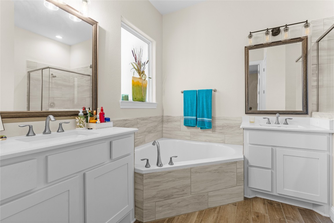 141 Sundog Road Huntsville, TX 77340 - Photo 45 of 49 a bathroom with a bathtub a double vanity sink and mirror