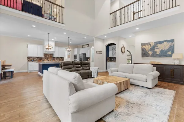 a living room with furniture kitchen view and a chandelier