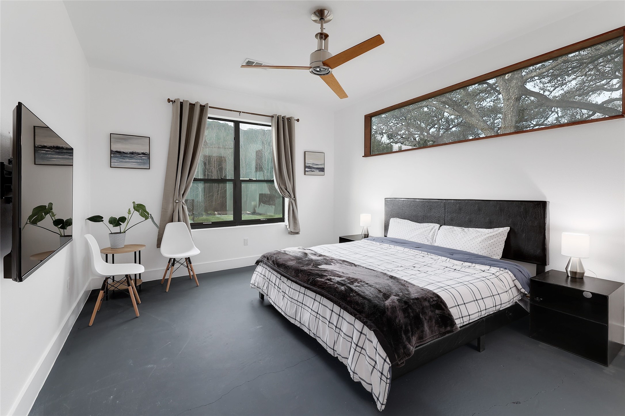 7001 Ranch Road 2222 Austin, TX 78730 - Photo 11 of 18 A tranquil primary bedroom features an extra-long window framing natural surroundings.