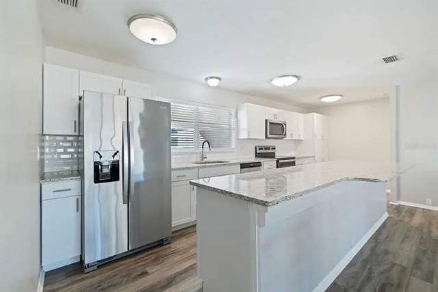 a kitchen with refrigerator and cabinets