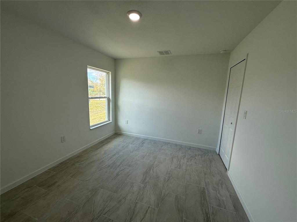 1288 Nackman Road North Port, FL 34288 - Photo 16 of 29 an empty room with wooden floor and windows