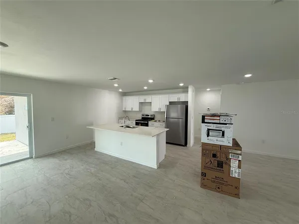 a view of kitchen with refrigerator sink and stove