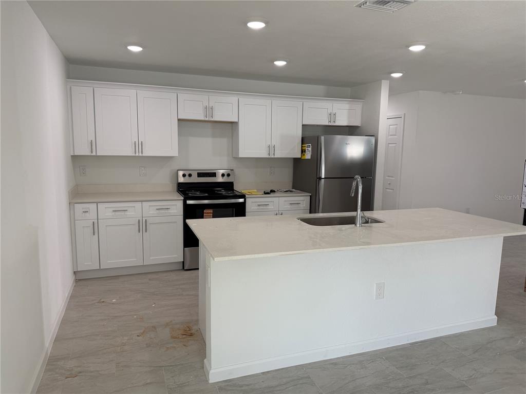 1288 Nackman Road North Port, FL 34288 - Photo 7 of 29 a kitchen with kitchen island a white counter top space cabinets and stainless steel appliances
