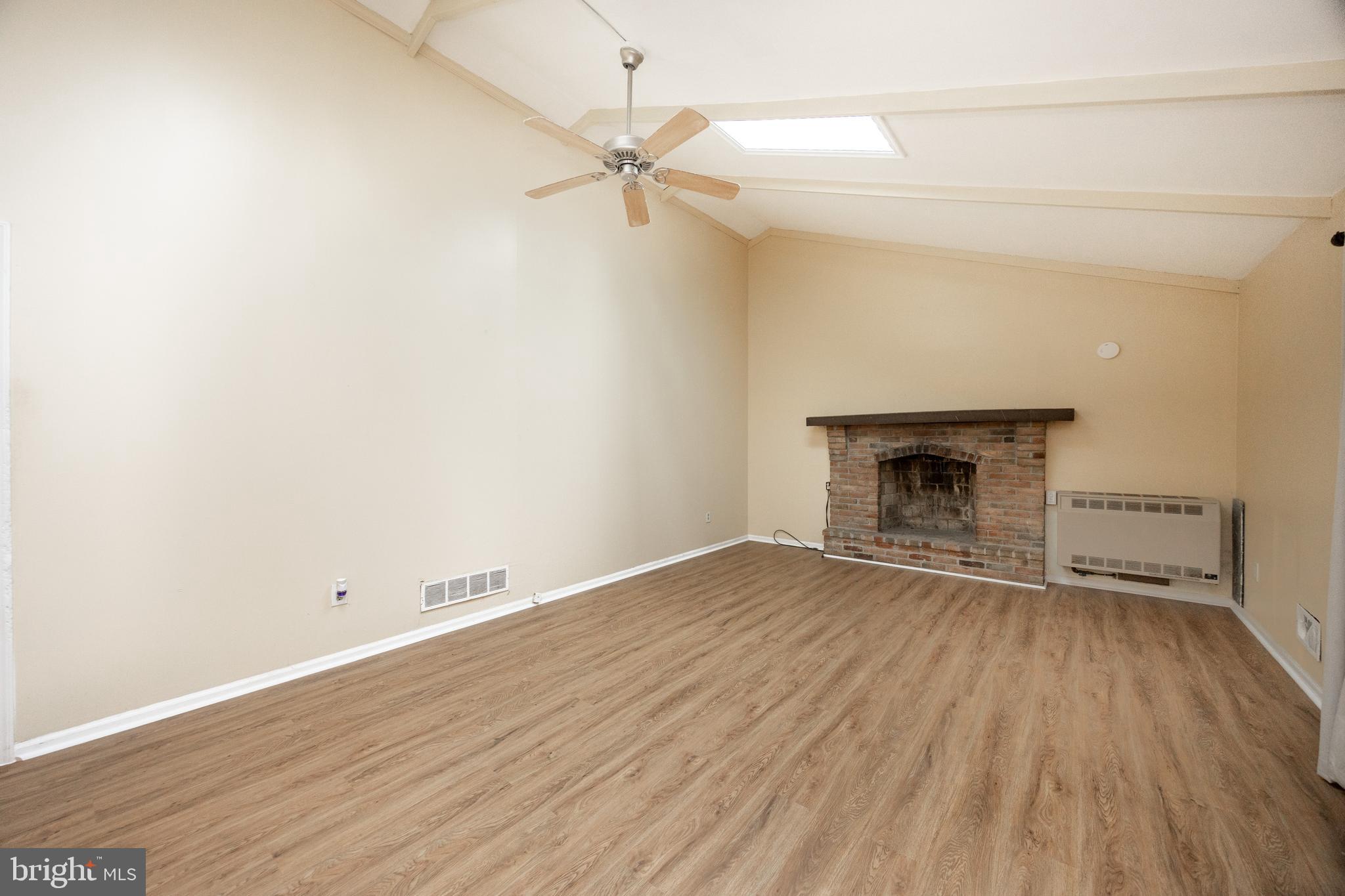175 Levengood Road Douglassville, PA 19518 - Photo 2 of 33 an empty room with wooden floor a fireplace and windows