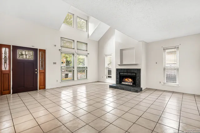 a view of an empty room with window and fire place