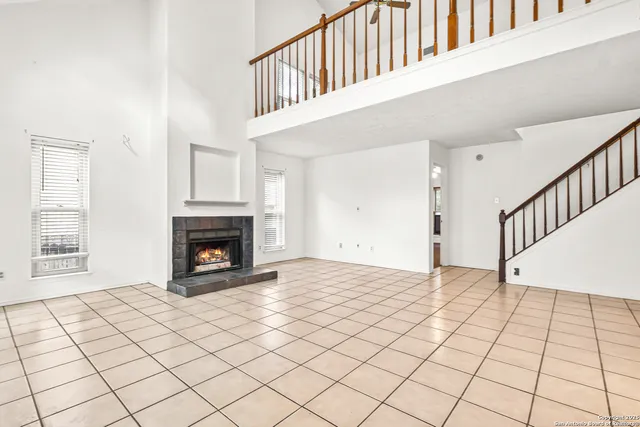 a view of an empty room with a fireplace and a window