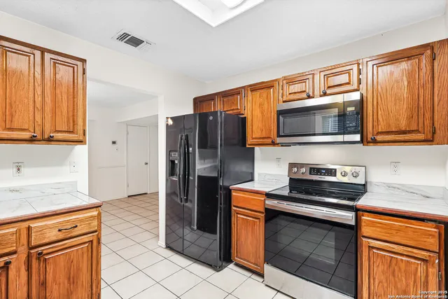 a kitchen with stainless steel appliances granite countertop a refrigerator stove microwave and sink