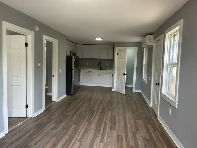 a kitchen with stainless steel appliances granite countertop a refrigerator and white cabinets