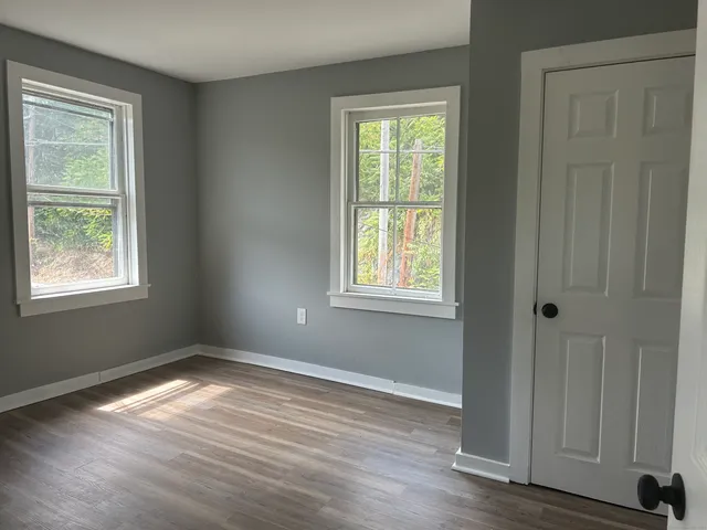 an empty room with wooden floor and closet