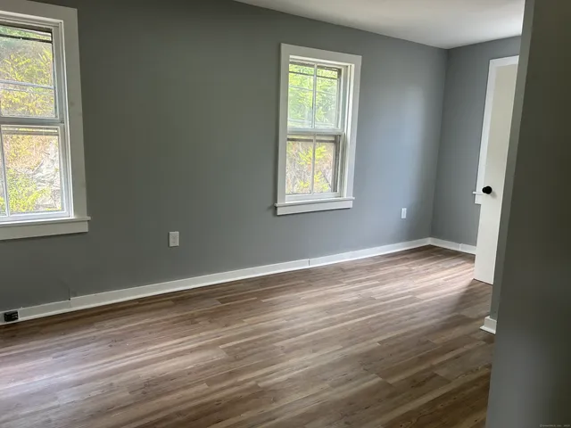 an empty room with wooden floor and a window