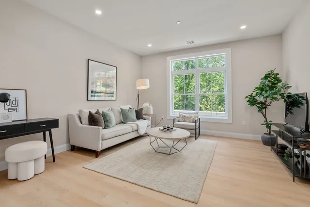 a living room with furniture and a large window with garden view
