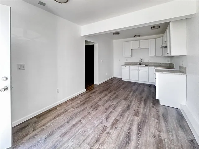 a large white kitchen with kitchen island sink refrigerator and white cabinets