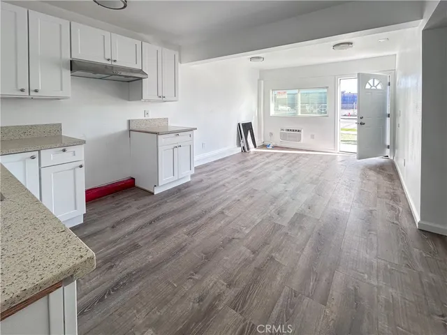 a kitchen with wooden floors and cabinets