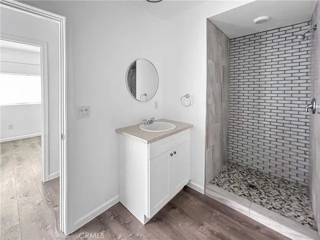 a bathroom with a granite countertop sink a mirror and shower
