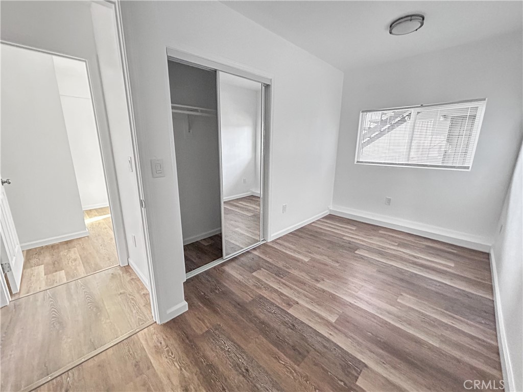 4215 Santa Ana Street, Unit O Huntington Park, CA 90255 - Photo 7 of 10 an empty room with wooden floor and windows