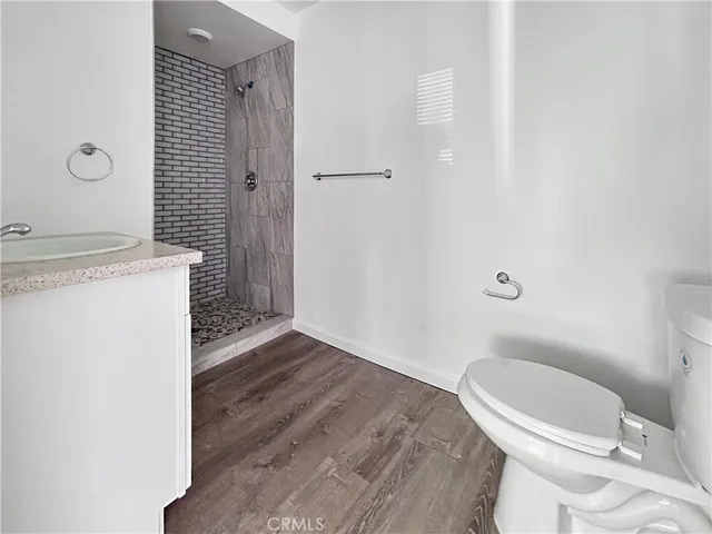 a bathroom with a granite countertop toilet and a sink