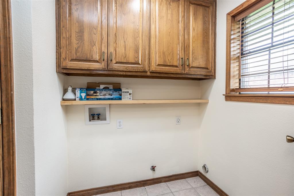 292 Old Spanish Trail Valley View, TX 76272 - Photo 14 of 40 Laundry area featuring washer hookup, cabinet space, light tile patterned floors, and hookup for a gas dryer