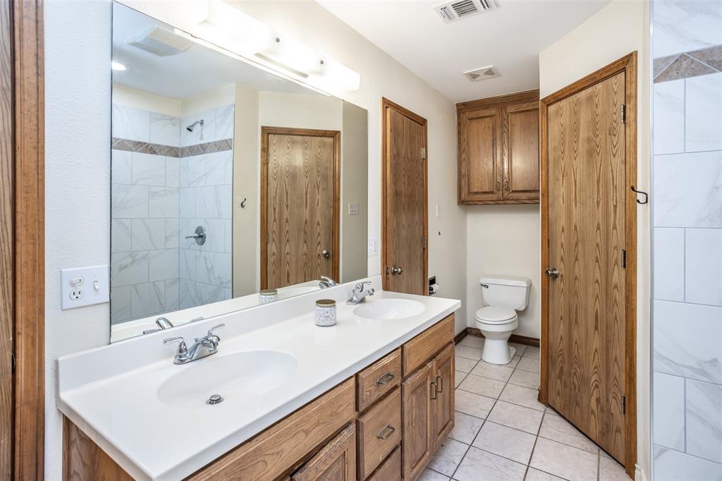 292 Old Spanish Trail Valley View, TX 76272 - Photo 24 of 40 Master bath featuring double vanity, tiled shower, and tile patterned flooring