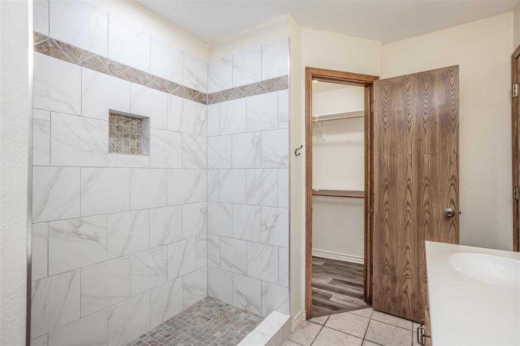 292 Old Spanish Trail Valley View, TX 76272 - Photo 26 of 40 Bathroom featuring tiled shower, 2 spacious closets, and vanity