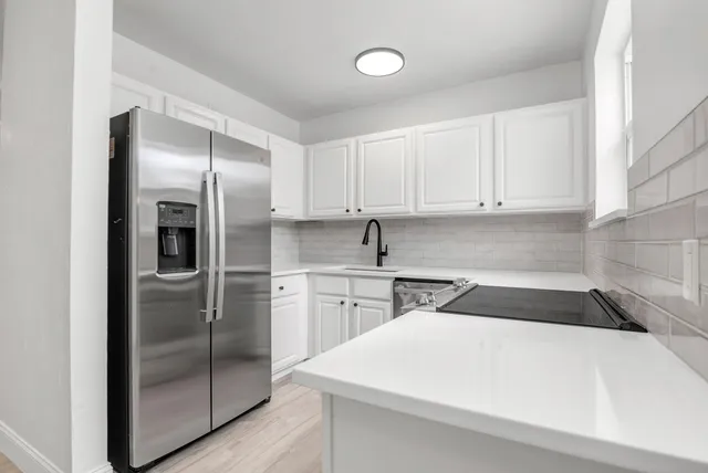 a kitchen with a refrigerator a sink and cabinets