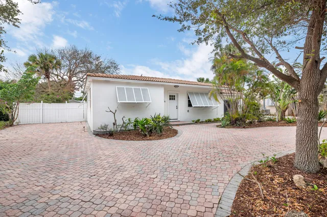 front view of house with a yard and trees
