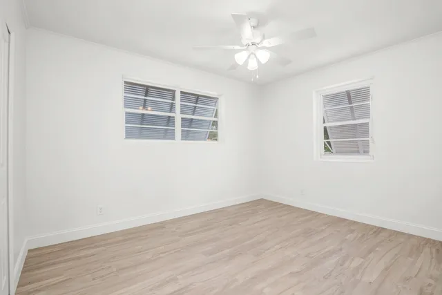 an empty room with wooden floor and window