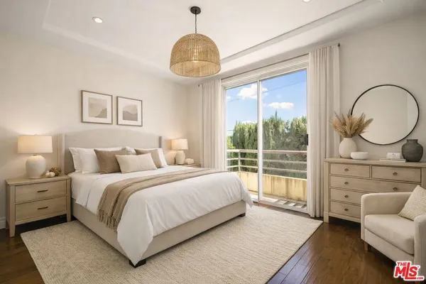 a bedroom with a large bed and a chandelier