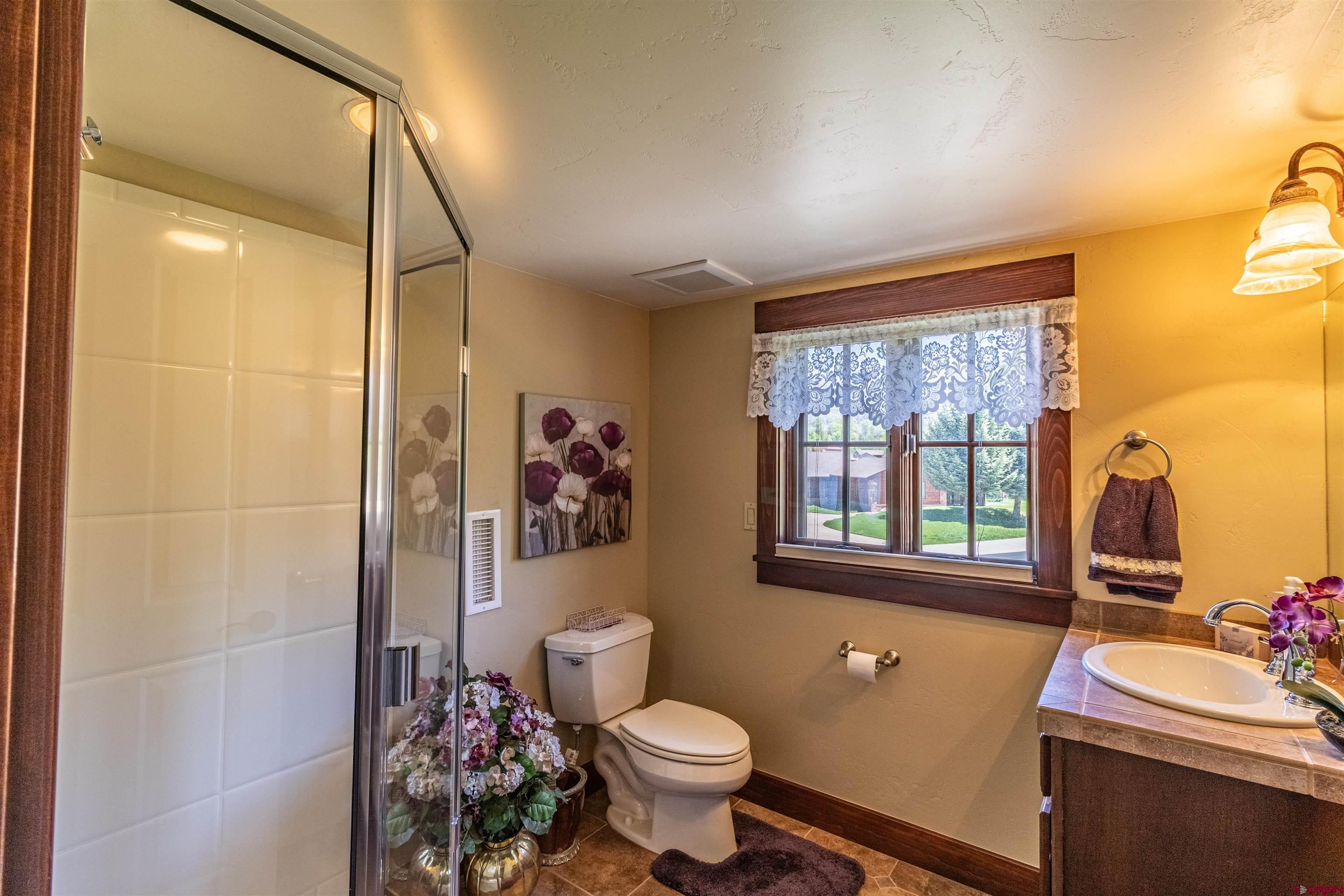 1167 North Dalton Ranch Road Durango, CO 81301 - Photo 31 of 45 a bathroom with a sink mirror toilet and next to a window
