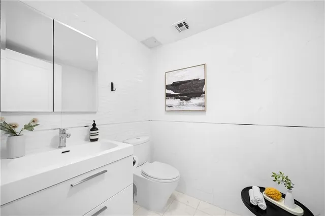 a bathroom with a sink mirror and toilet