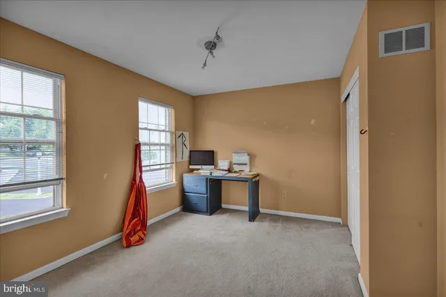 a view of a workspace with furniture and a window