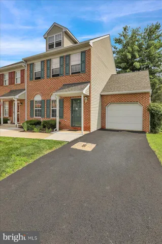 a front view of a house with a garden and trees