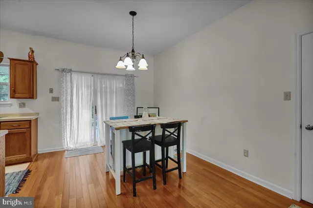 a view of a dining room with furniture wooden floor and a chandelier