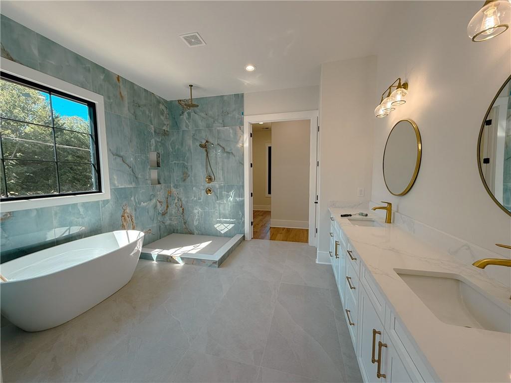 3700 Robinson Road Northeast Marietta, GA 30068 - Photo 19 of 49 a bathroom with a tub a double vanity sink toilet a mirror and a bathtub