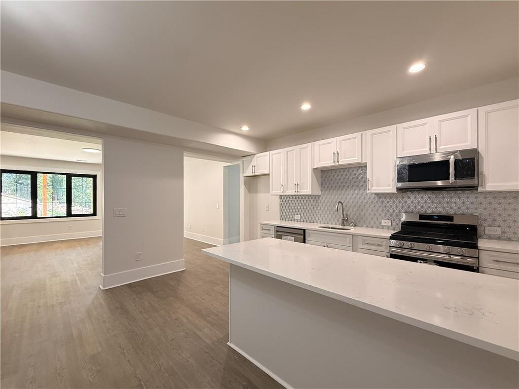 3700 Robinson Road Northeast Marietta, GA 30068 - Photo 37 of 49 a large kitchen with stainless steel appliances a large counter top a stove a microwave and a refrigerator