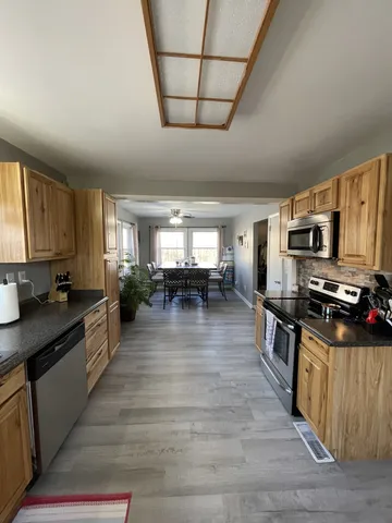 a large kitchen with lots of counter space and wooden floor