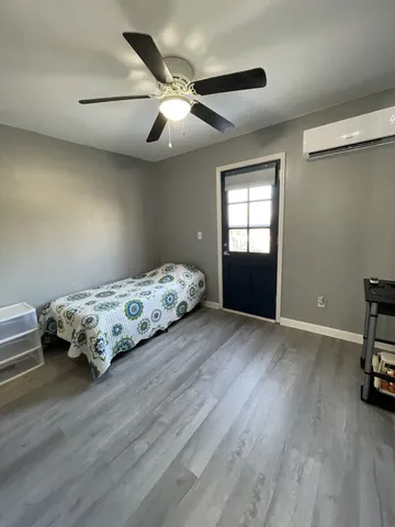 a bedroom with a bed and a ceiling fan