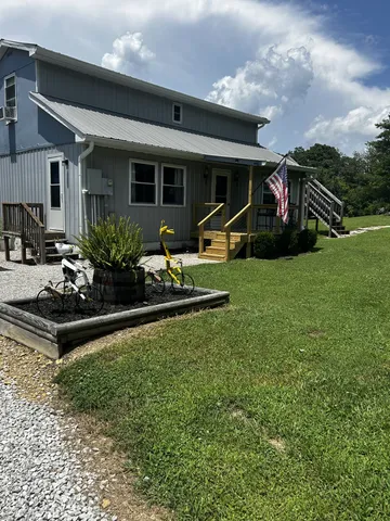 a view of a house with backyard sitting area and garden