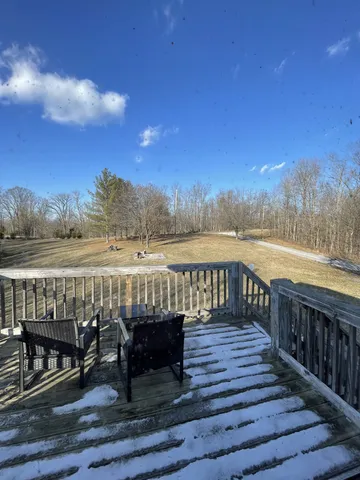 a view of a balcony with wooden chairs and city view