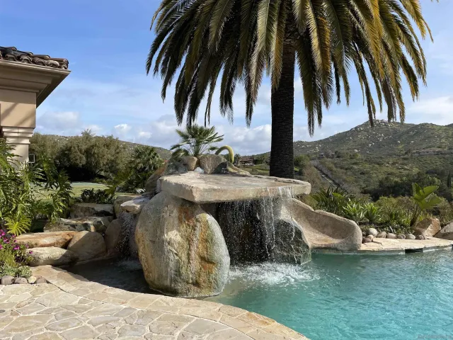 a kitchen with stainless steel appliances granite countertop a sink a counter space and a view of living room