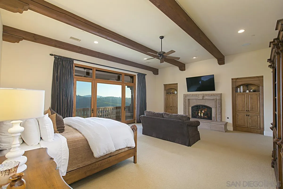 14155 Bryce Point Poway, CA 92064 - Photo 32 of 71 a spacious bedroom with a large bed and a fireplace