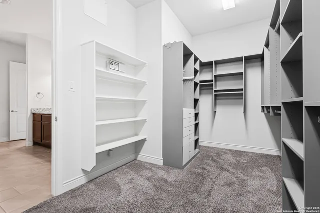 a view of walk in closet with clothes and shoes