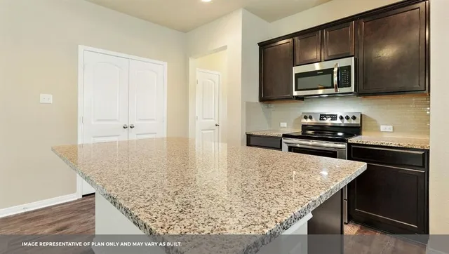 a kitchen with stainless steel appliances granite countertop a sink and microwave