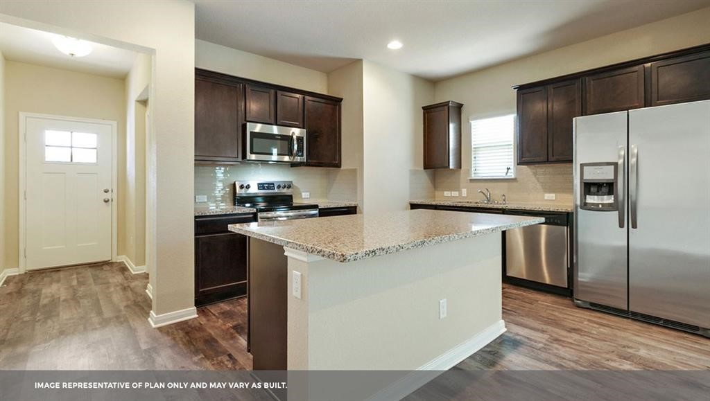 14909 Custis Lane Austin, TX 78725 - Photo 16 of 21 a kitchen with stainless steel appliances granite countertop a refrigerator a stove a sink and a microwave