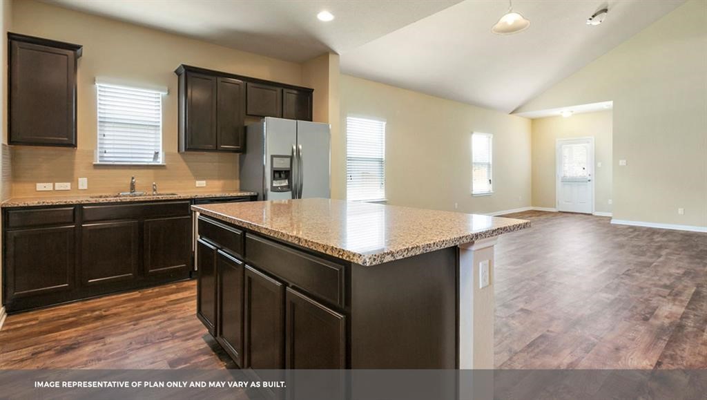 14909 Custis Lane Austin, TX 78725 - Photo 17 of 21 a kitchen with a sink a stove a refrigerator and a microwave
