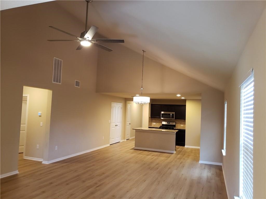 14909 Custis Lane Austin, TX 78725 - Photo 3 of 21 a view of a kitchen with a sink dishwasher and a microwave
